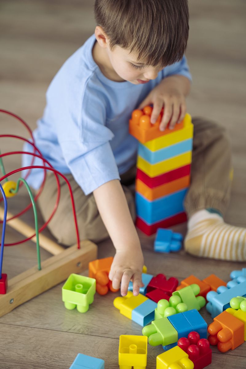 Un bambino costruisce una torre con i mattoncini colorati